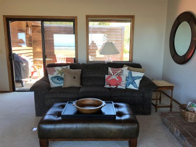 Couch in the family room with sliding glass door to the deck