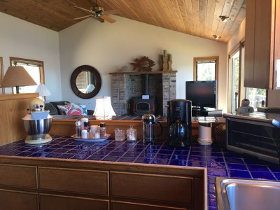 Fully furnished kitchen with family room behind it.